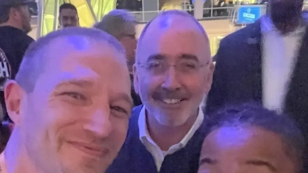 Raymond Jensen, wearing a yellow lanyard, poses with UAW President Shawn Fain at a UAW event in Washington, D.C.